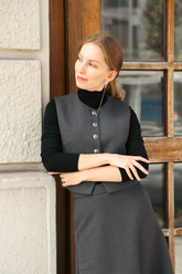 a lady in a black knit top and a grey wool blend vest and skirt two-piece set
